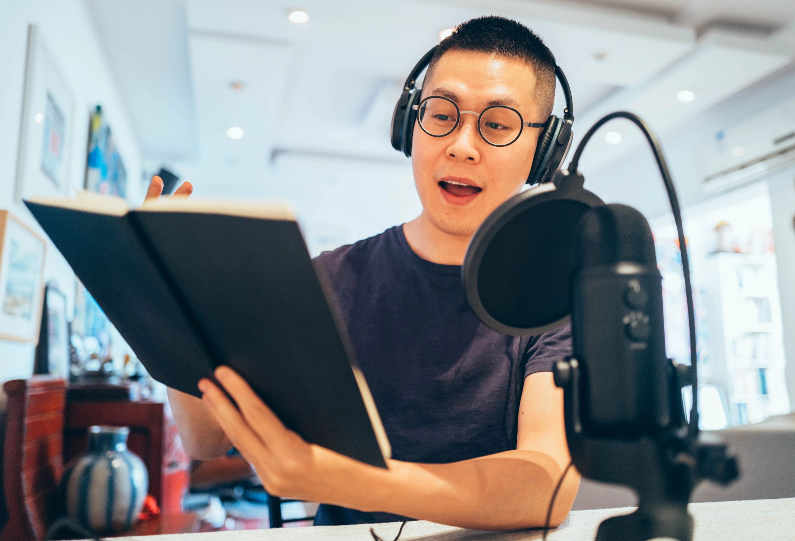 Voice actor recording audiobook narration in a studio booth