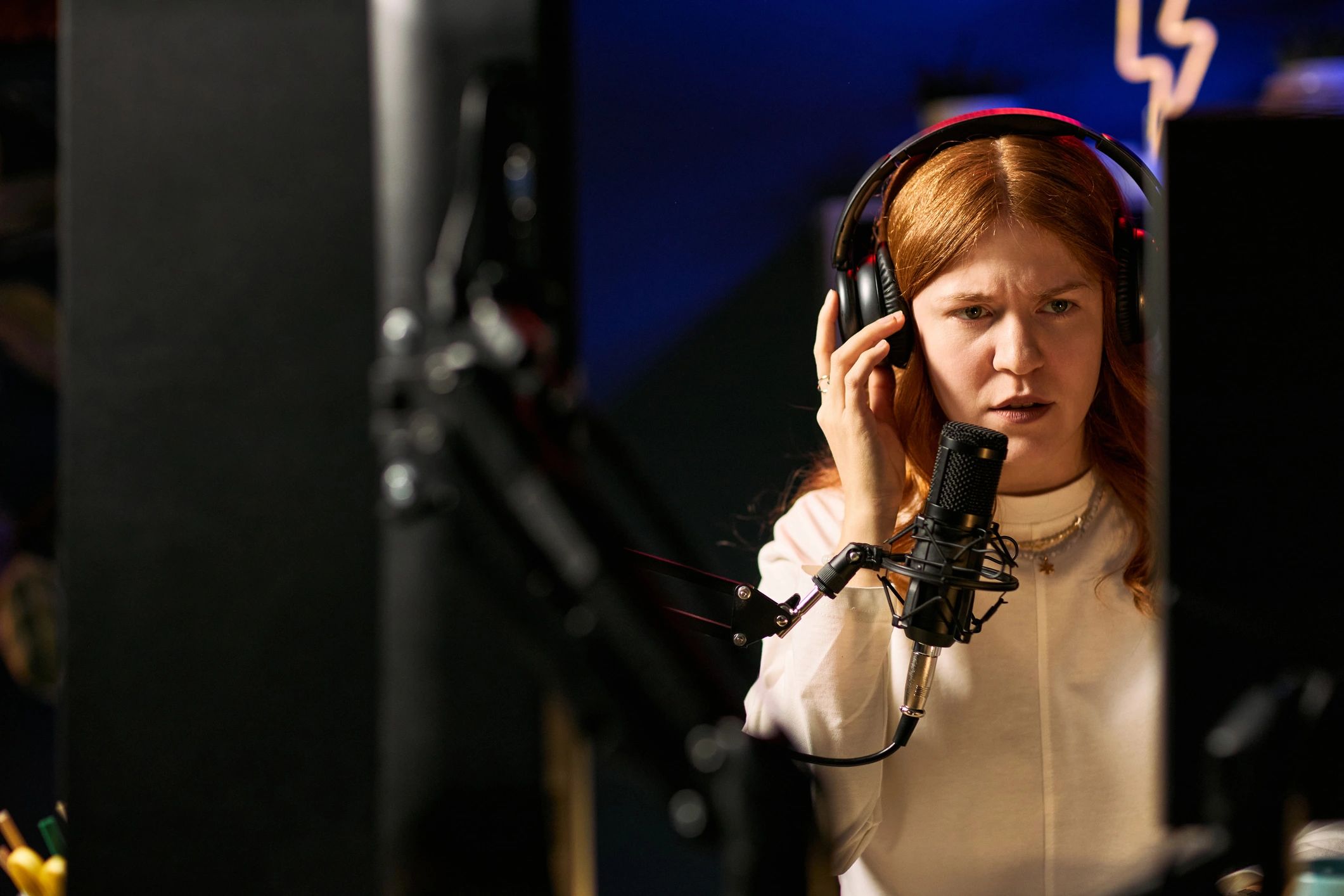 Voice actor recording with headphones and microphone in studio